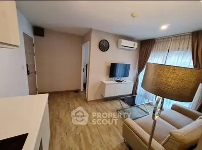 Modern living room with wooden flooring, cozy sofa, and wall-mounted TV in a stylish apartment.