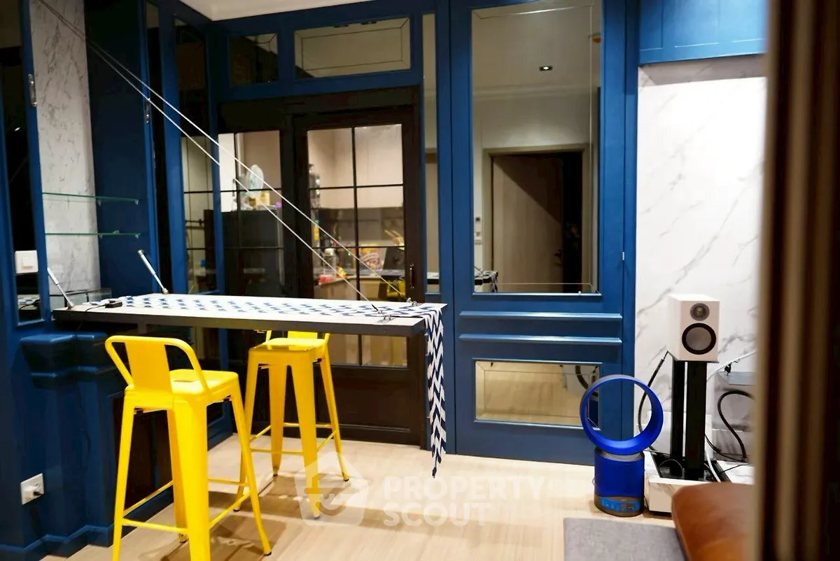 Modern interior with vibrant blue accents and yellow bar stools in a stylish living space.