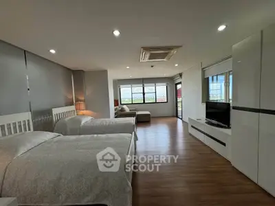 Spacious modern bedroom with twin beds and large windows offering a scenic view.