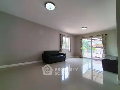 Spacious living room with large windows and modern lighting