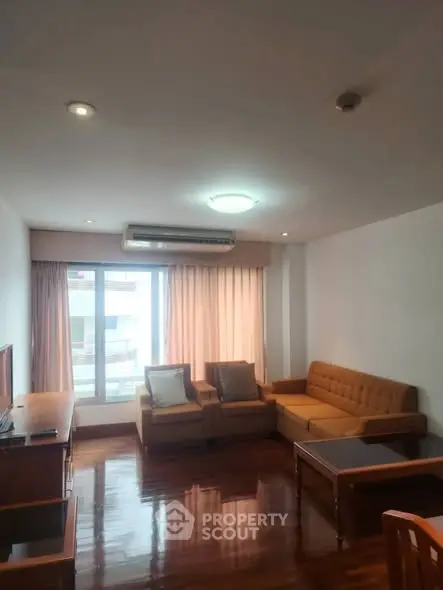 Spacious living room with modern furniture and large window for natural light.