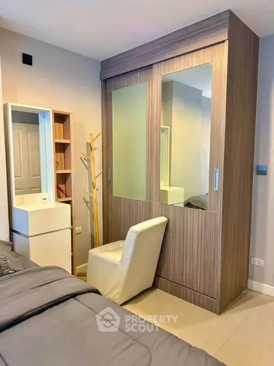 Modern bedroom with sleek wardrobe and cozy chair, perfect for stylish living.