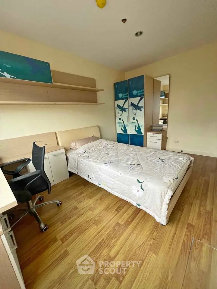 Cozy bedroom with wooden flooring and modern furniture in a bright apartment