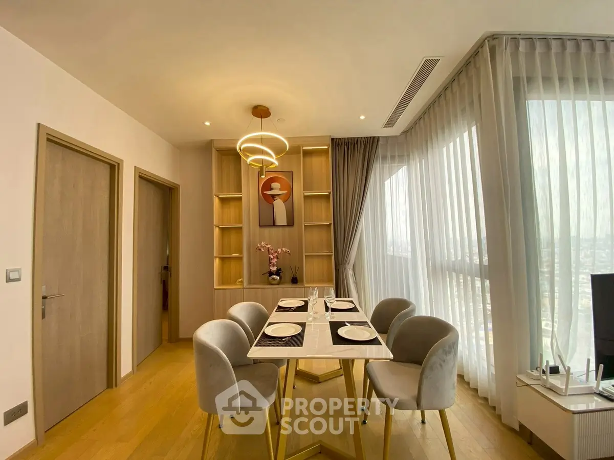 Elegant dining area with modern decor and large windows offering city views.