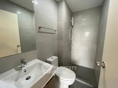 Modern bathroom with sleek fixtures and walk-in shower in contemporary apartment.