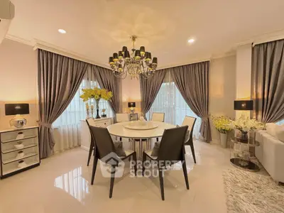 Elegant dining room with chandelier, stylish curtains, and modern decor in a luxurious home setting.