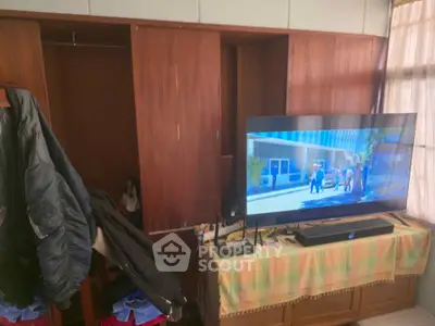 Cozy living room with wooden cabinets and modern TV setup.