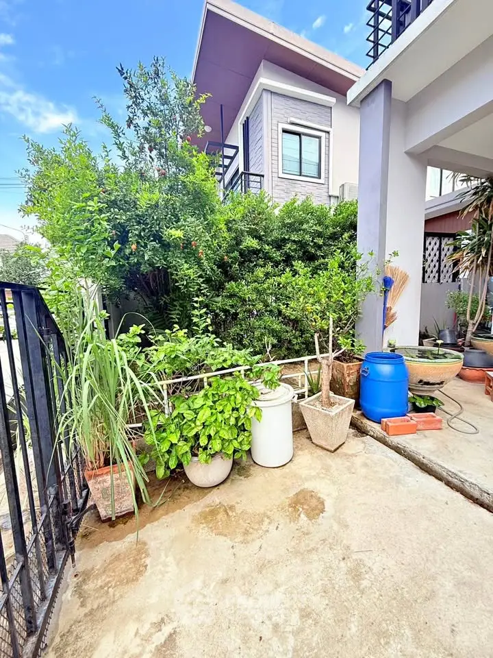 Charming exterior view of a modern house with lush greenery and a spacious patio area.