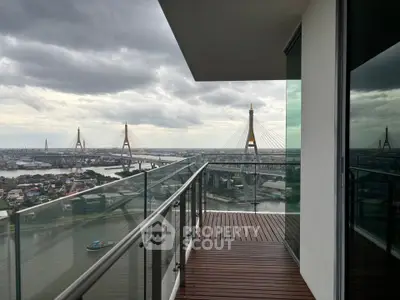 Stunning balcony view of river and bridge from high-rise apartment, perfect for urban living.