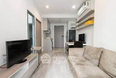 Modern living room with cozy sofa, TV, and open kitchen in stylish apartment.