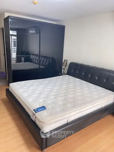 Modern bedroom with sleek black furniture and comfortable mattress