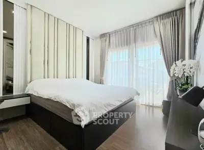 Spacious modern bedroom with elegant decor and large windows