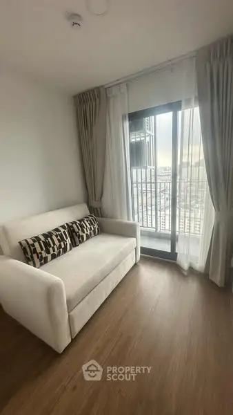 Cozy living room with a modern sofa and city view from a large window