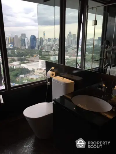 Luxurious bathroom with stunning city skyline view from high-rise apartment.