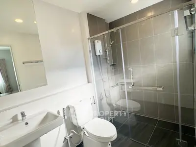 Modern bathroom with glass shower and sleek fixtures in a contemporary home.