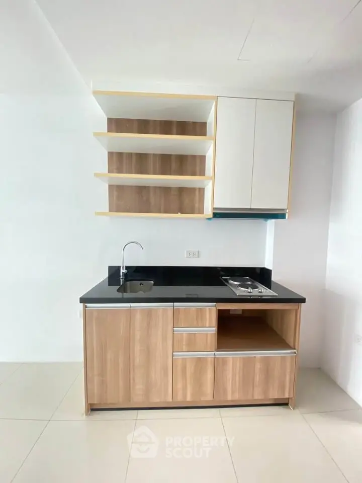 Modern minimalist kitchen with sleek cabinetry and black countertop
