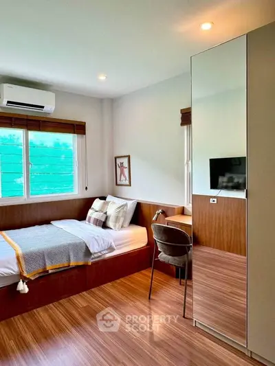 Cozy modern bedroom with wooden flooring and stylish decor