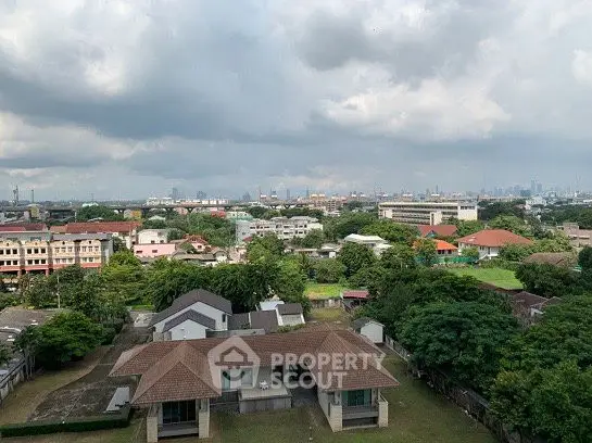 Stunning aerial view of suburban homes with lush greenery and city skyline in the distance.