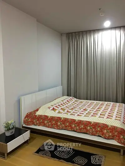 Cozy bedroom with modern decor and stylish bedding in a well-lit apartment.