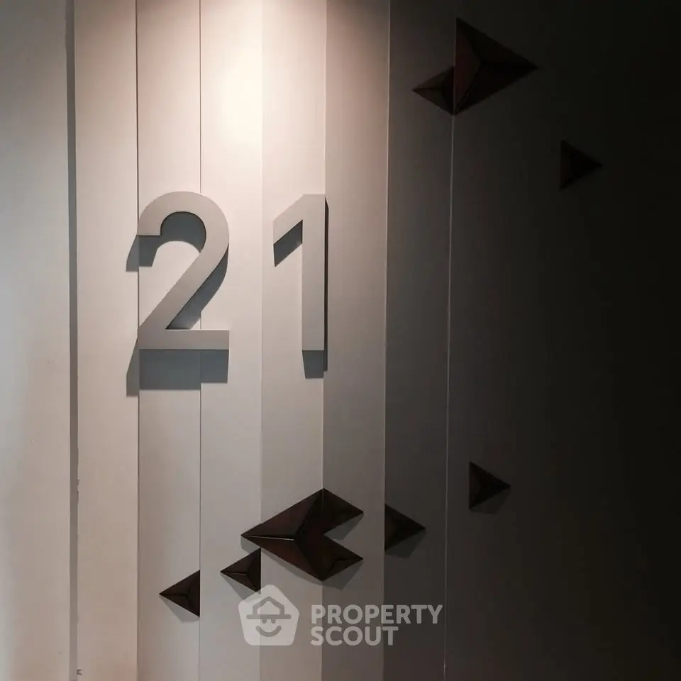 Modern building interior with stylish wall decor and number 21 displayed prominently.