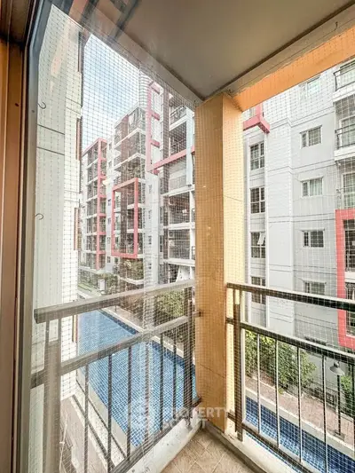 Charming balcony view overlooking modern apartment complex with pool