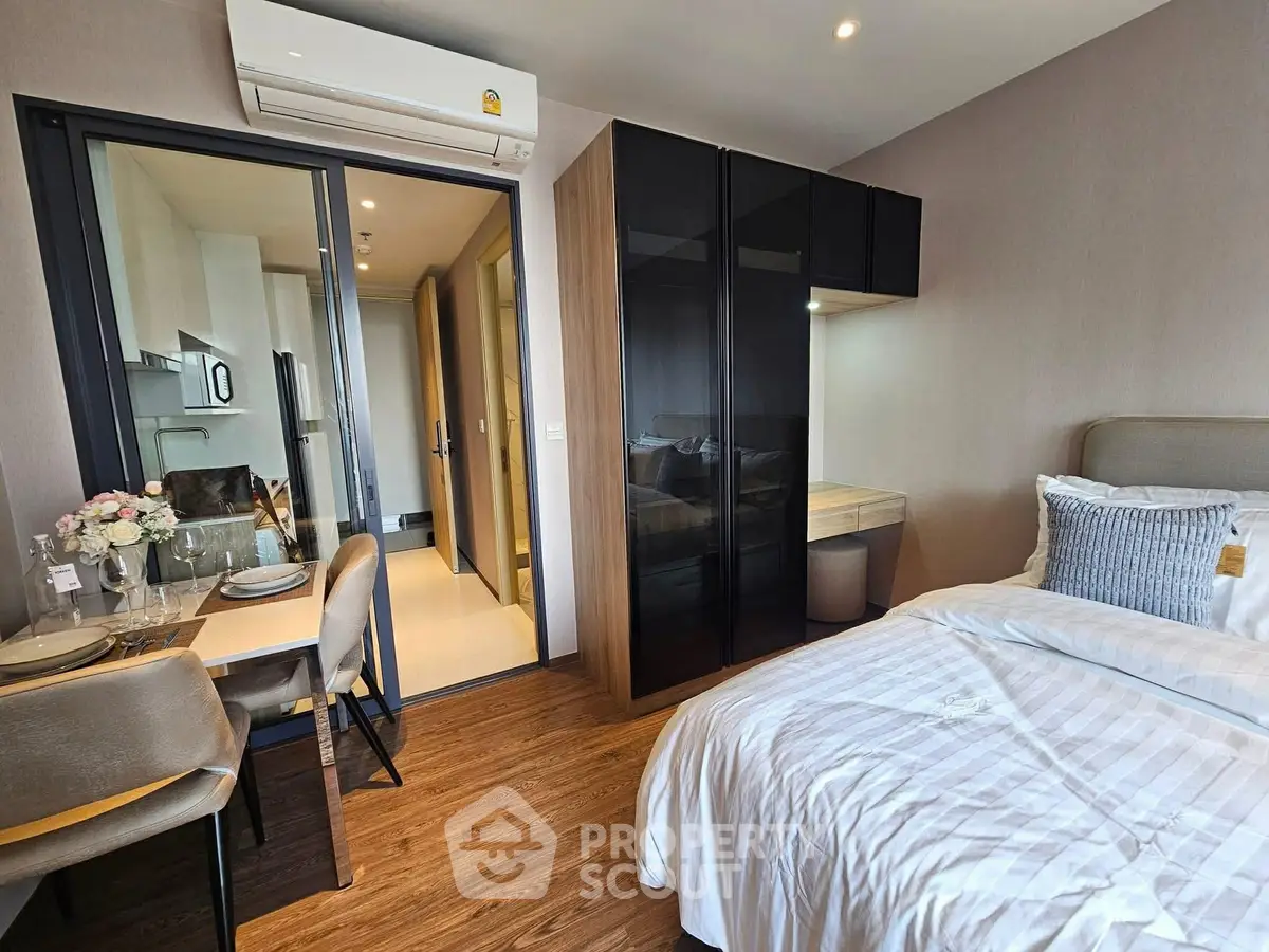 Modern bedroom with dining area and sleek kitchen in open layout apartment