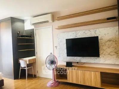 Modern living room with wall-mounted TV, air conditioning, and stylish wooden shelves.
