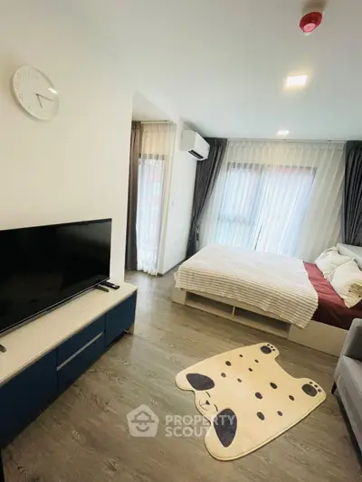 Modern bedroom with stylish decor, featuring a cozy bed, TV, and large windows with sheer curtains.