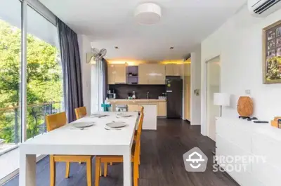 Modern open-layout kitchen and dining area with natural light and balcony view.