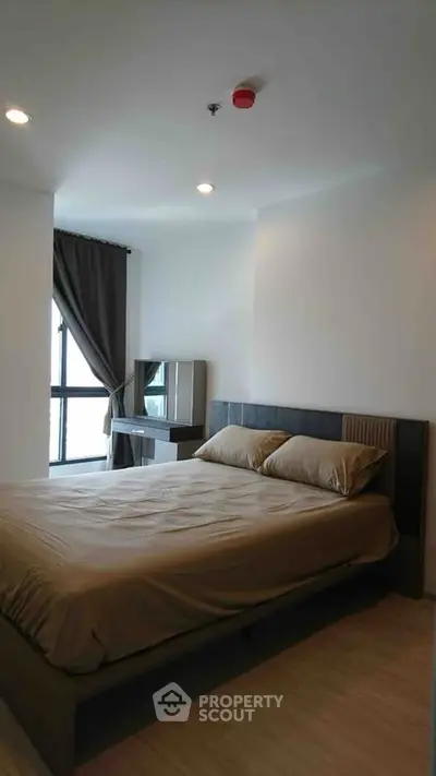 Modern bedroom with large window and stylish decor in a high-rise apartment.