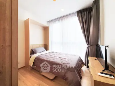 Cozy bedroom with natural light and modern furnishings in a stylish apartment.