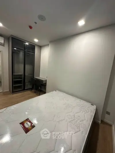 Modern bedroom with sleek wardrobe and cozy workspace in stylish apartment.