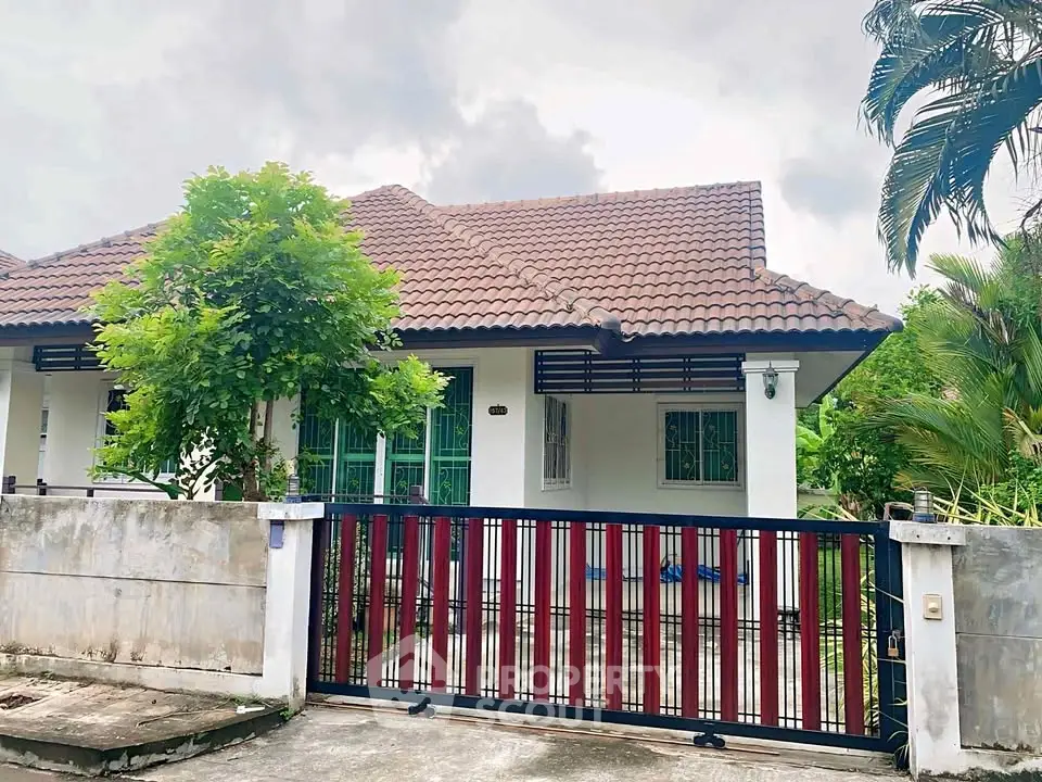 Charming single-story house with tiled roof and lush greenery