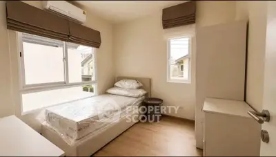 Cozy bedroom with natural light and modern furnishings in a stylish home.