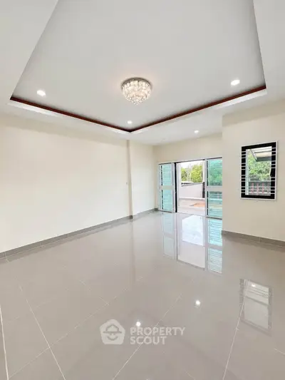 Spacious modern living room with glossy tiled floors and elegant ceiling light.