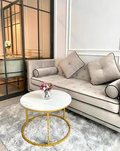 Elegant living room with plush sofa and chic round coffee table on a soft rug.