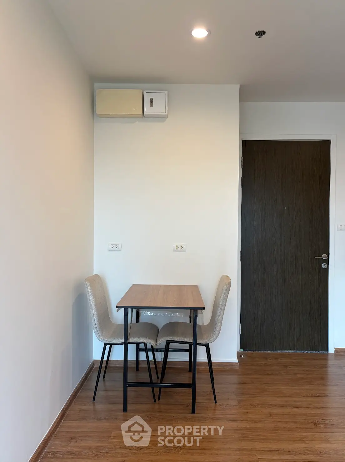 Cozy minimalist dining area with wooden table and chairs, perfect for small spaces.