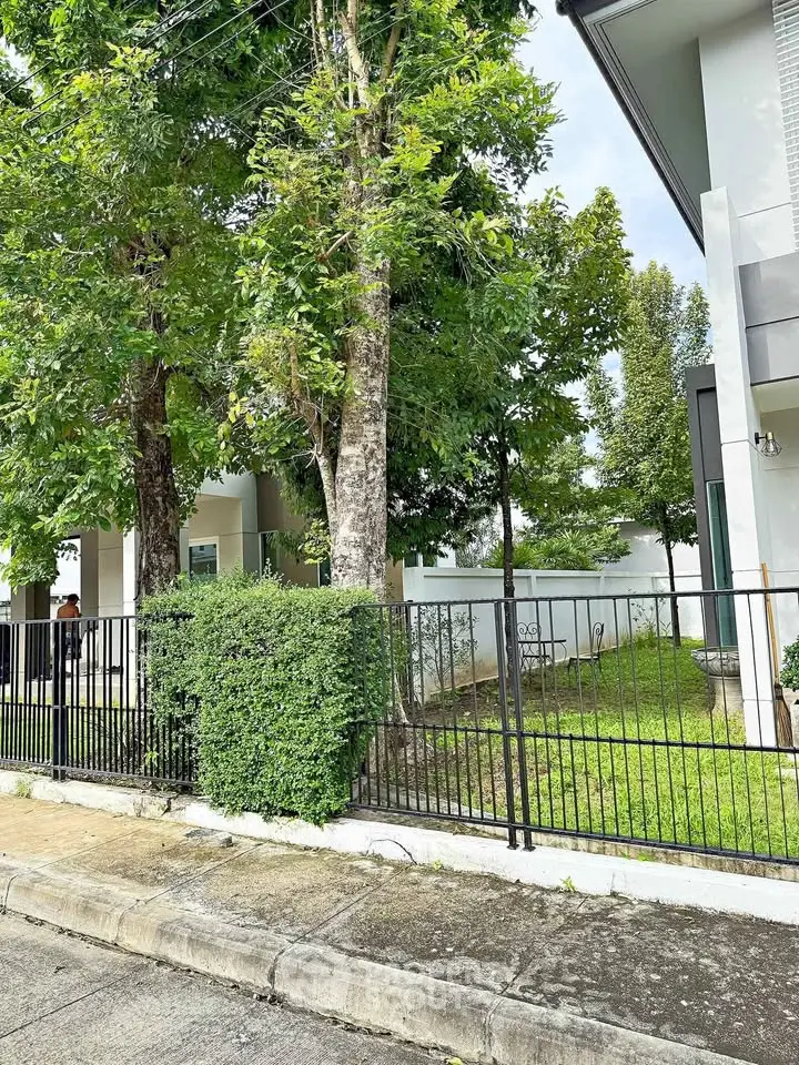 Modern residential building with lush greenery and secure fencing