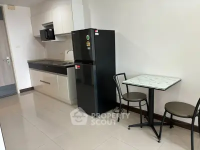 Modern kitchen with sleek appliances and dining area in a stylish apartment.