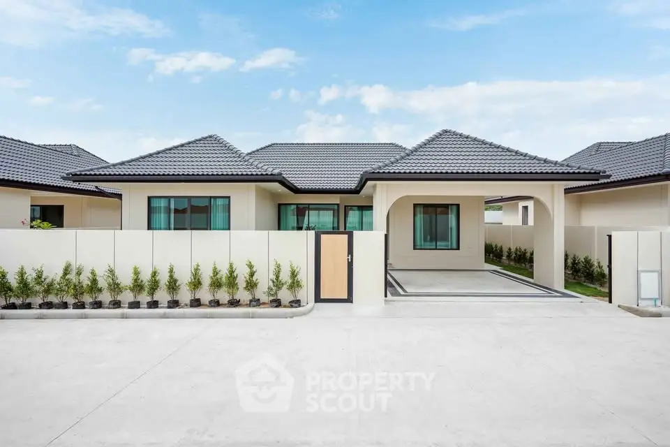 Modern single-story house with sleek design and spacious driveway in a serene neighborhood.