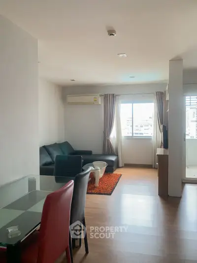 Spacious living room with modern furniture and city view, perfect for urban living.