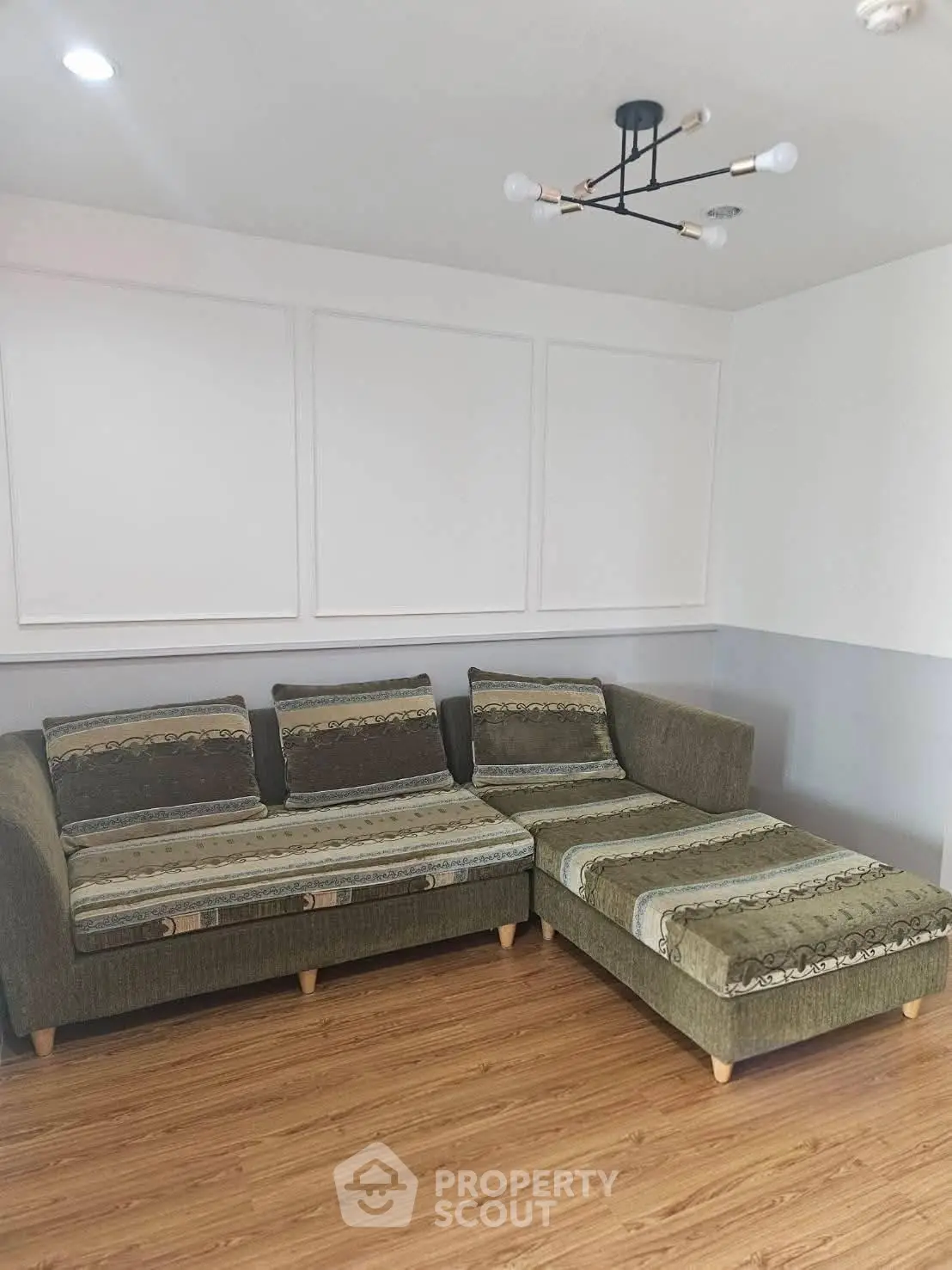 Stylish living room with modern sectional sofa and elegant lighting fixture.