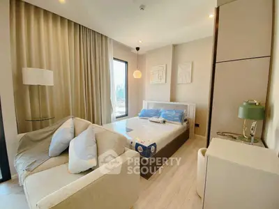 Modern bedroom with cozy sofa and large window offering natural light