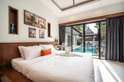 Luxurious bedroom with pool view in tropical villa, featuring elegant decor and abundant natural light.