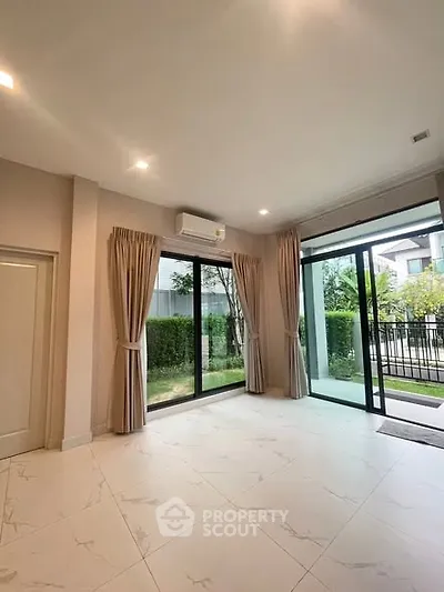 Spacious living room with large windows and garden view