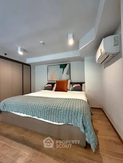 Modern bedroom with stylish decor and air conditioning in a cozy apartment.