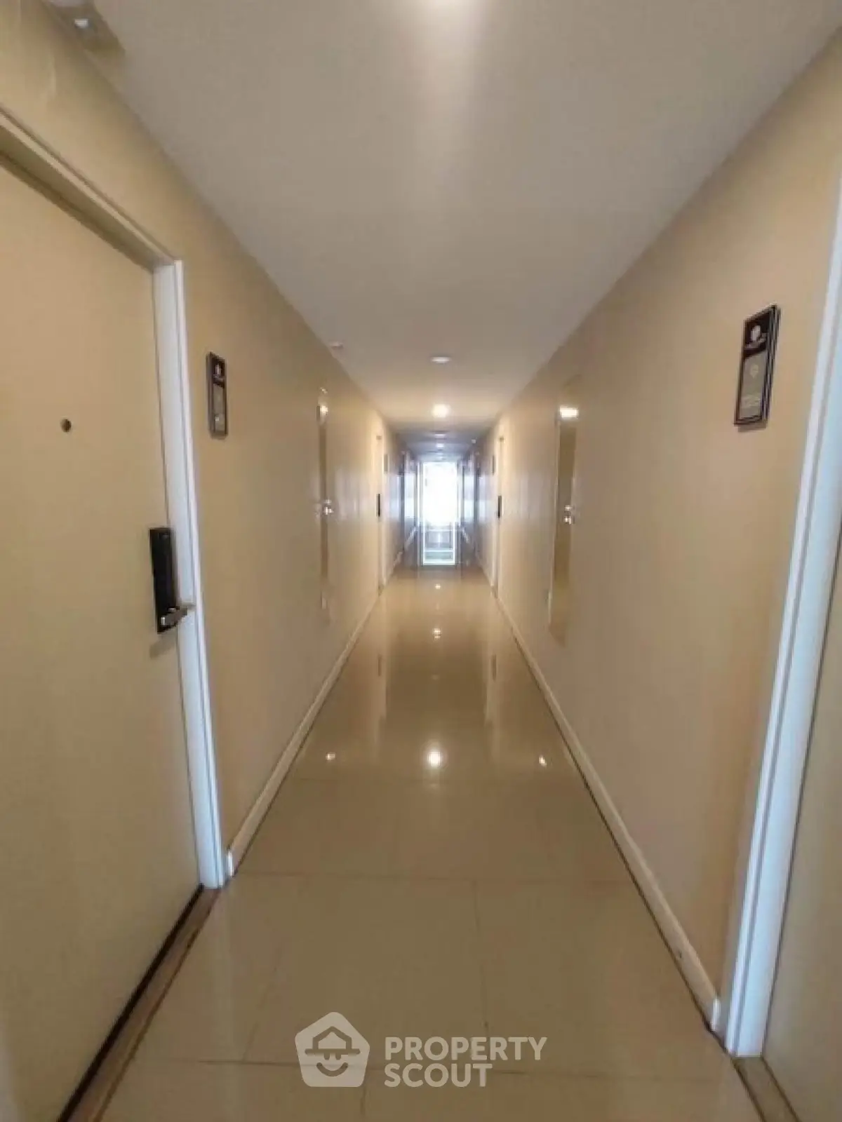 Spacious and well-lit apartment corridor with polished floors and modern design.