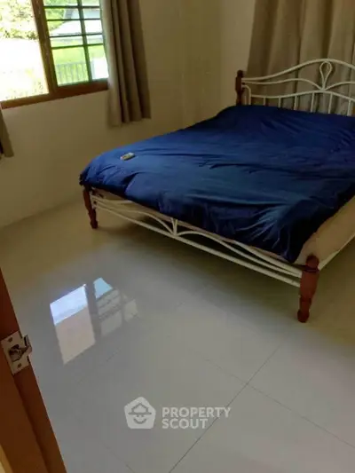 Cozy bedroom with elegant metal bed frame and large window view