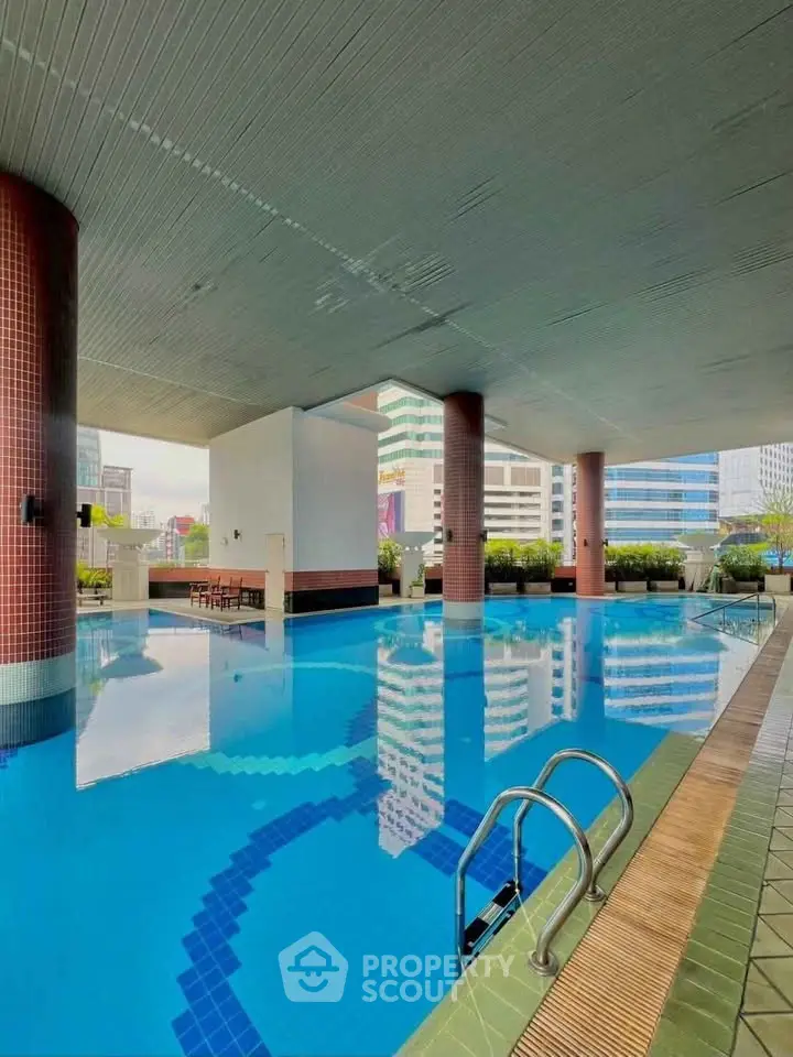 Luxurious rooftop pool with city views in modern high-rise building.