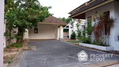 Charming residential driveway with lush greenery and spacious carport